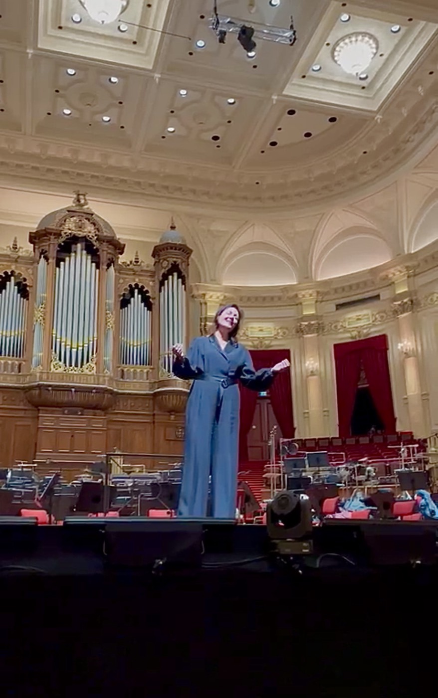 Debby Mureau op het podium van het Concertgebouw, uitgelicht door een spot