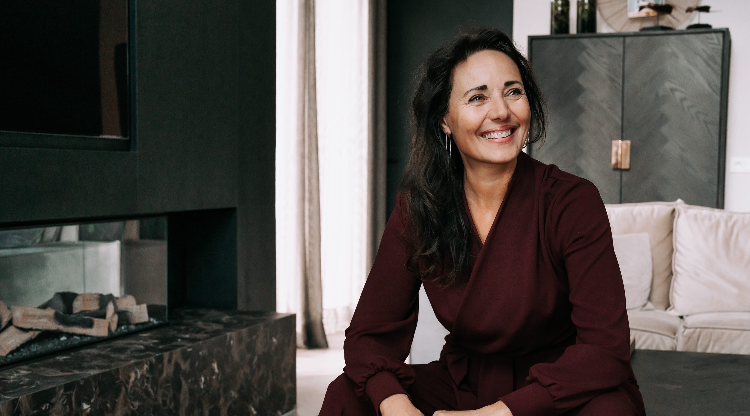 Debby Mureau zit lachend in een lichte kamer