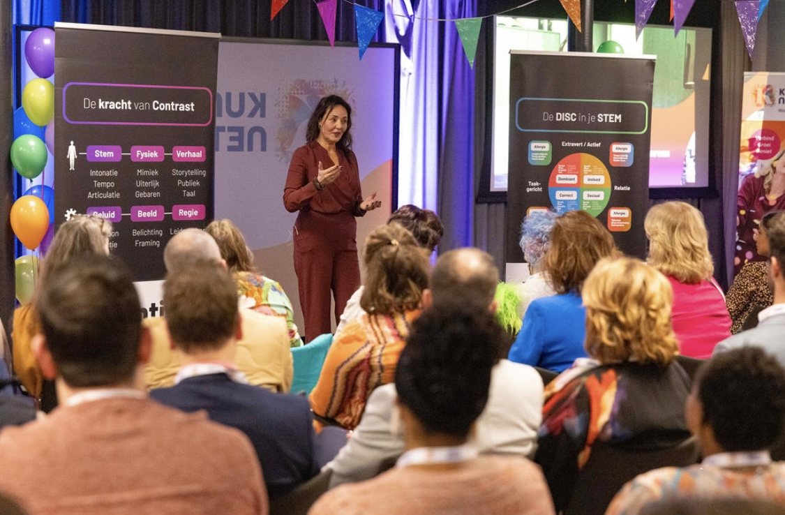 Debby Mureau geeft een training voor een zaal vol deelnemers